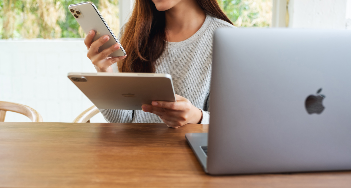 A person editing photos on an iPad and an iPhone.