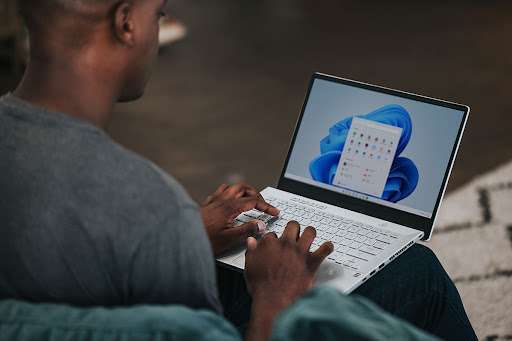 Man working on his laptop with MS Office icons on the screen.